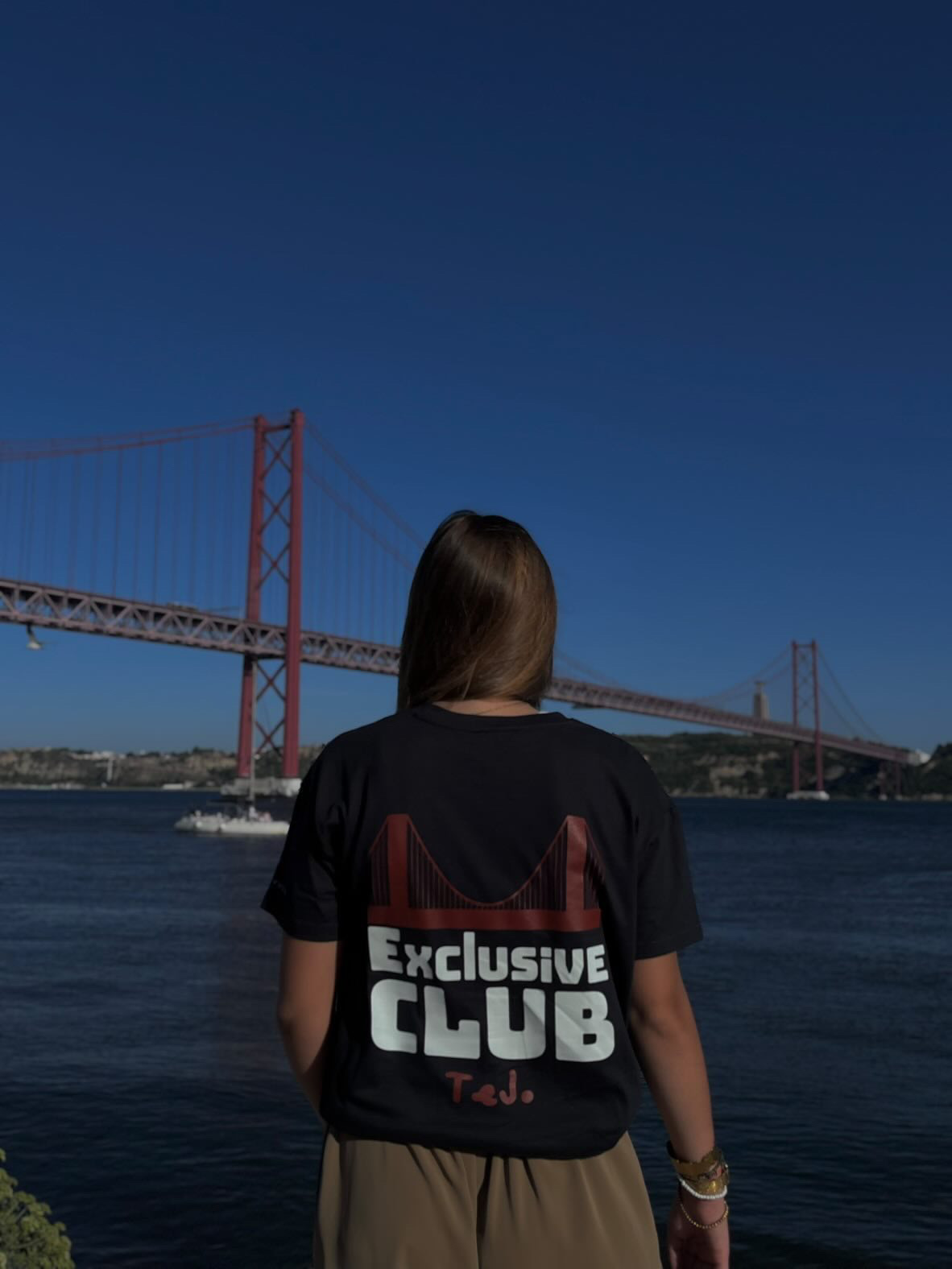 Corte mais justo da t-shirt Exclusive Club, vista de costas com o gráfico da ponte.