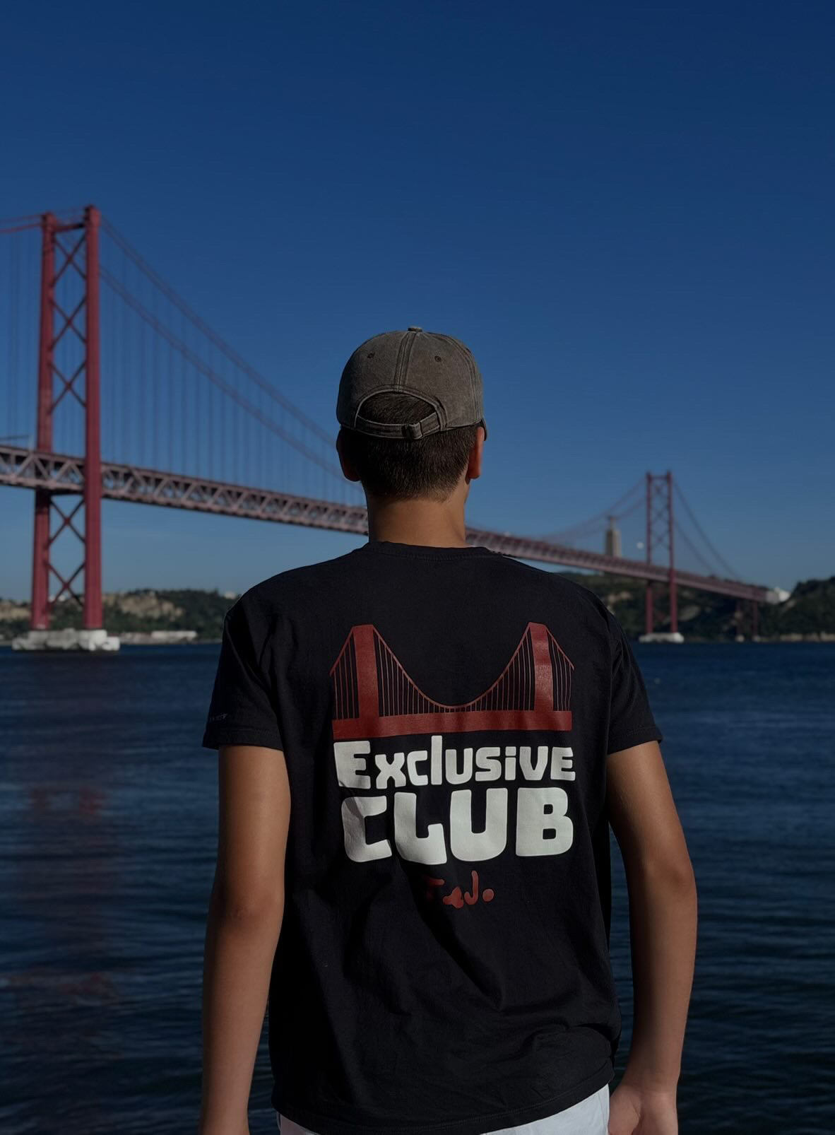 Costas da t-shirt: ponte 25 de Abril a vermelho sobre as letras Exclusive Club a branco.