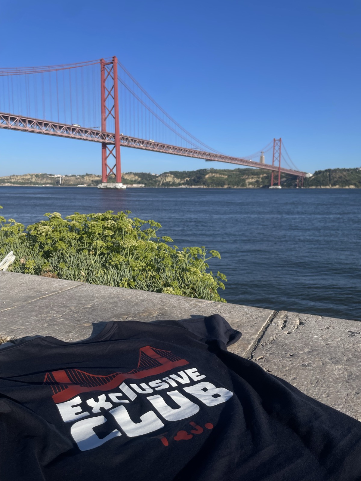 A t-shirt Exclusive Club estendida no cais, ao sol.